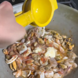 The image shows the process of adding lemon juice to the seafood medley