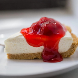 this image shows cheesecake garnished with fresh berries and syrup and ready to serve