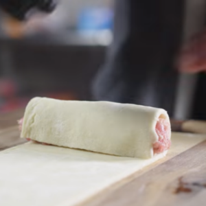 The image shows the process of filling of pork mix into irish pastry