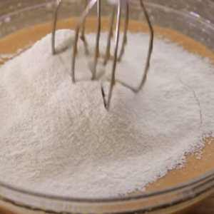 The image shows the process of mixing batter for dulce de leche cake