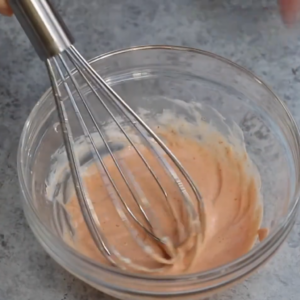 This image shows the process of mixing together spicy chili sauce and smooth mayonnaise