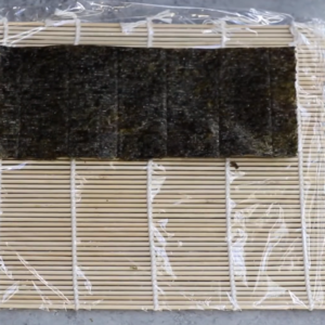 this image shows a glossy nori sheet, ready to cradle a bed of sticky sushi rice