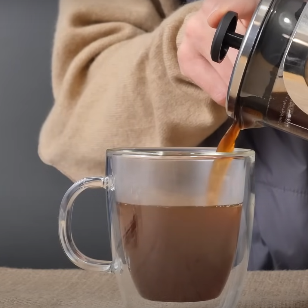 This image shows french press coffeee in cup ready to serve