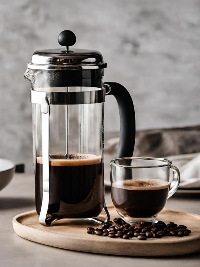 The image shows french press coffee served in a cup with coffee maker on the side