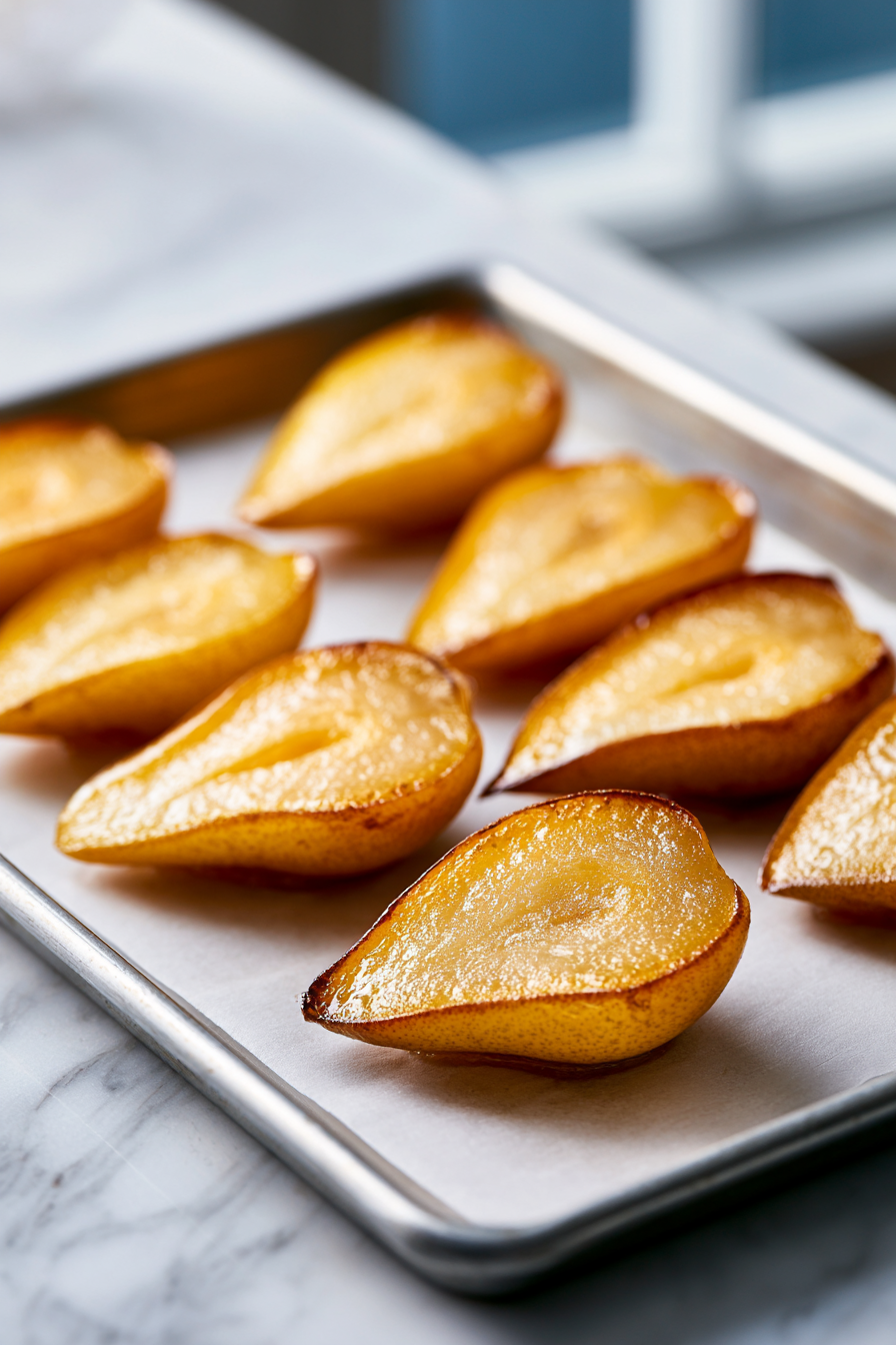 Drizzle olive oil over halved pears, season with salt and pepper, and roast for 10 minutes until tender.