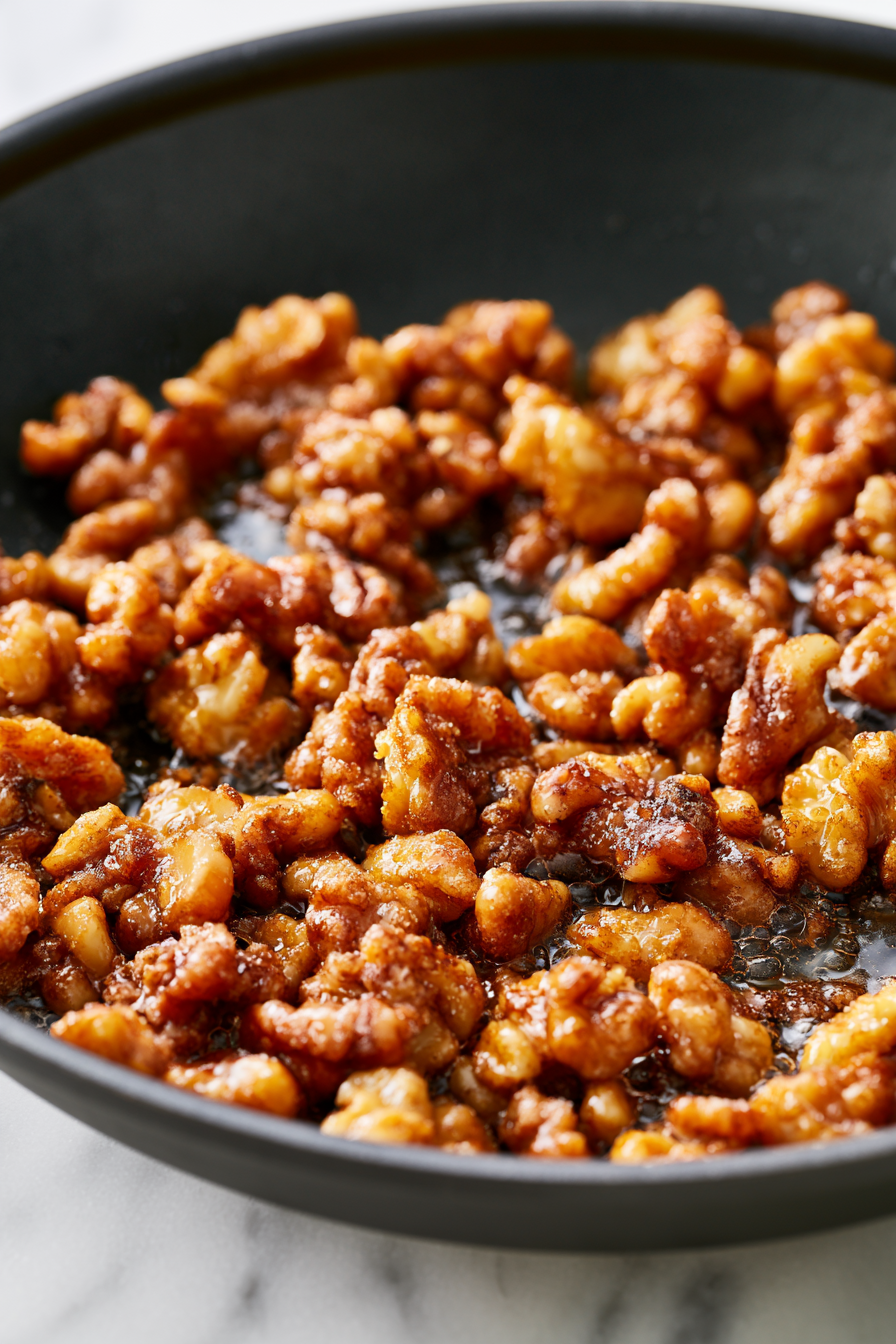 Fry sugared walnuts in oil until golden brown, then drain and set aside.