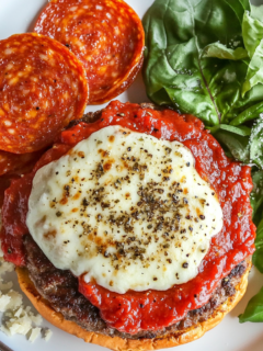 This image shows ground beef being mixed with Italian seasoning, pizza spices like oregano and garlic, creating a flavorful beef mixture in preparation for making pizza burgers.