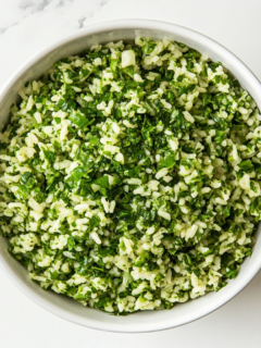 A serving of vibrant Chimichurri rice garnished with fresh parsley and cilantro in a bowl, ready to be served as a side dish.