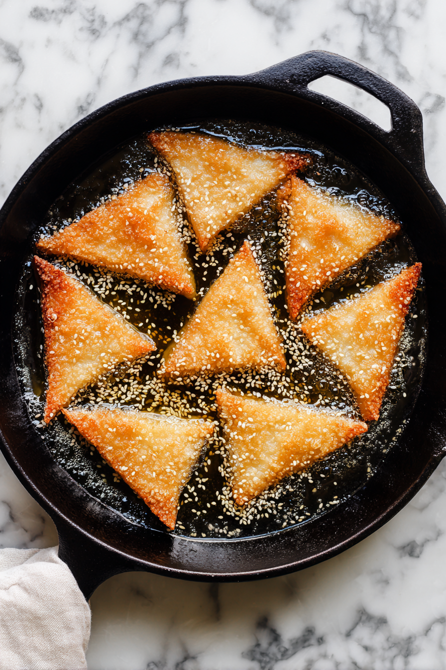 Heat oil in a skillet, fry triangles until golden and crispy, flipping as needed.