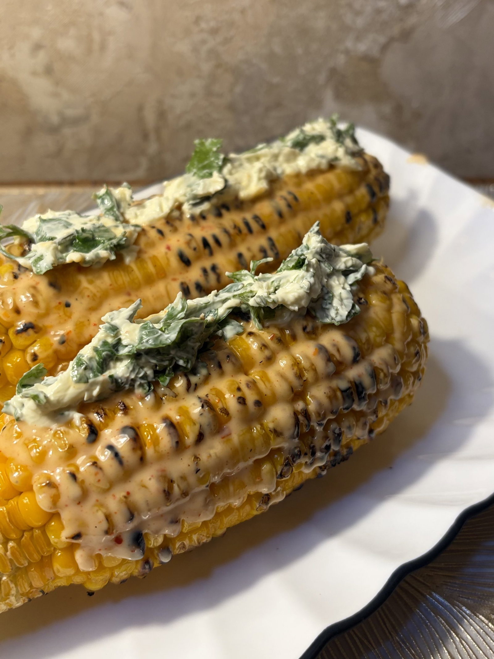 Hold it over a plate and sprinkle the cheese-cilantro blend liberally, rotating to coat all sides—expect a bit of mess.