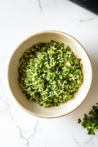 A serving of vibrant Chimichurri rice garnished with fresh parsley and cilantro in a bowl, ready to be served as a side dish.