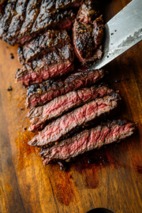 This image shows grilled flap steak resting before being sliced thinly against the grain, preparing it for serving.