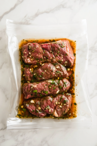 This image shows the marinade being poured over flap steak in a container, ensuring the meat is well-coated before being refrigerated to marinate