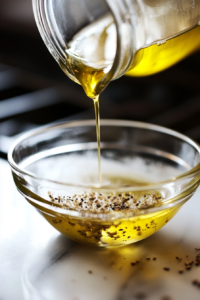 A small bowl with olive oil, cream, lemon juice, salt, and pepper, whisked into a smooth, zesty dressing for the fennel walnut salad