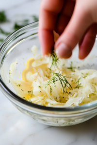 Chopped fennel fronds mixed with lemon zest in a small bowl, ready to garnish the fennel walnut salad with a fresh citrusy touch