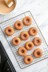 Coating Warm Baked Apple Cider Doughnuts with Cinnamon Sugar