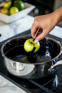 Dipping Apples into Black Caramel Mixture