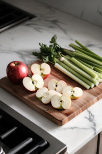 Fresh green apples celery and green onions being rinsed under cold water for apple salad recipe preparation