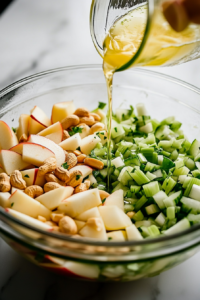 Freshly prepared ingredients combined in a large mixing bowl for apple salad