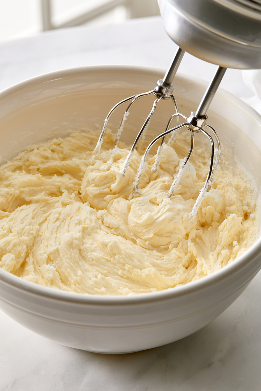 In a bowl, beat together the butter, sugar, egg, almond extract, and vanilla extract until well combined