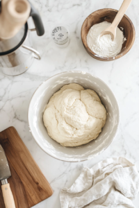 Kneading cinnamon-apple babka dough by hand on a floured surface