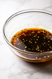 Mixing soy sauce, molasses, garlic, and ginger marinade for chicken wings