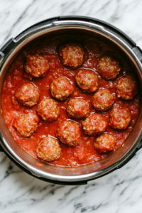 Preparing the Instant Pot by Spraying with Cooking Spray and Pouring in Spaghetti Sauce