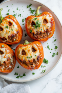 Serving hot spooky stuffed peppers garnished with cheese for spooky stuffed peppers recipe