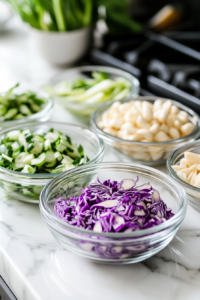 This image shows shredded cooled chicken being prepared. The chicken is shredded into large pieces for the chicken salad