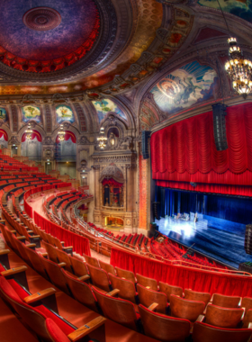 A beautiful exterior view of the historic BP Theater in Chicago, showcasing its unique architecture and vibrant signage. The theater is a renowned venue for performing arts, offering a variety of shows and events throughout the year. This image captures the charm and cultural significance of the theater within the city’s artistic landscape.