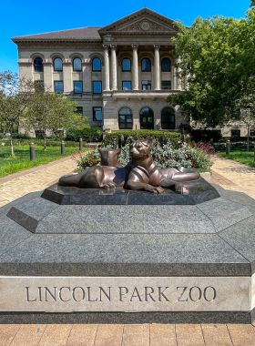  A vibrant view of the entrance to Lincoln Park Zoo in Chicago, showcasing lush greenery and visitors enjoying the beautiful surroundings. The zoo is home to a diverse range of animals and serves as a popular destination for families and nature lovers. The image captures the welcoming atmosphere and scenic pathways that define this urban oasis.