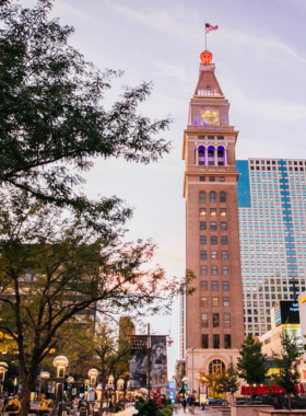 A bustling scene of the 16th Street Mall in Denver, filled with shoppers and outdoor dining. The image captures the vibrant atmosphere of the urban space, showcasing the blend of shopping, dining, and community interaction.