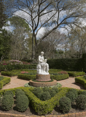 "A beautiful view of Bayou Bend Gardens with manicured landscapes, lush greenery, and historic architecture set amidst tranquil scenery."