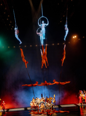 Cirque du Soleil performance in Las Vegas, showcasing acrobatic artists in vibrant costumes performing on stage, blending theater, dance, and aerial stunts.