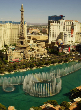 The Bellagio Fountains in Las Vegas performing a synchronized water show, with jets of water reaching high into the air against the backdrop of the iconic Bellagio hotel.