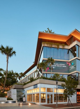 Charming streetscape of CocoWalk on Grand Avenue, showcasing a bustling outdoor shopping area with vibrant shops, dining options, and lively patrons enjoying the atmosphere.