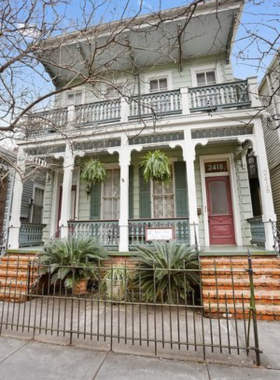 Classic New Orleans home in the Garden District, featuring beautiful architecture with intricate ironwork and lush landscaping, representing the elegance and historic charm of the area.