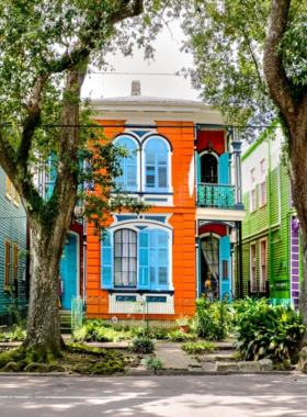 Historic French Quarter street in New Orleans, featuring colorful buildings, ornate ironwork balconies, and lively crowds, encapsulating the charm and culture of this famous district.