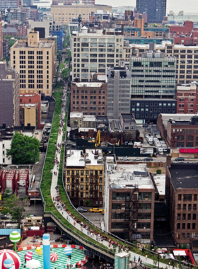 Elevated view of the High Line in New York City, a unique park built on a former railway track, featuring lush greenery, modern art, and cityscape views.

