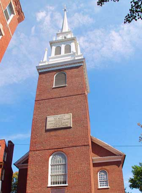 The historic Old North Church in Boston, known for its colonial-era architecture and significant role in the American Revolution. The image shows the church’s tall steeple against a blue sky, symbolizing Boston’s rich historical heritage.