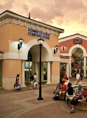 Exterior view of the Orlando International Premium Outlets, featuring upscale brand shops and large walkway spaces, a popular shopping destination for visitors seeking deals on high-end merchandise.