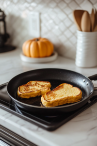 Preheating a skillet or griddle over medium heat in preparation for making Pumpkin French Toast.