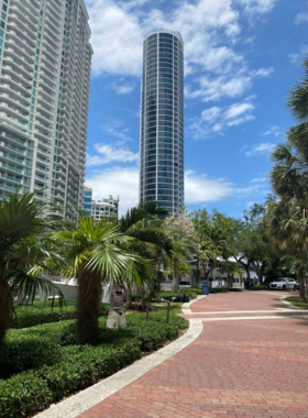 This image shows Fort Lauderdale’s scenic Riverwalk, a riverside pathway with lush greenery, pedestrian-friendly areas, and waterfront views, where locals and tourists enjoy peaceful walks.