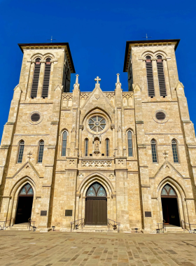 The beautiful San Fernando Cathedral, featuring intricate Gothic architecture, stands against a clear blue sky. The historic church’s grand design captures its cultural significance and charm.