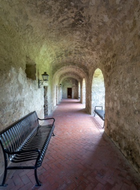 A well-preserved, historic mission church with weathered stone walls, surrounded by lush greenery. This centuries-old structure represents cultural heritage and architectural beauty.

