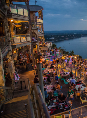 A view of the Oasis restaurant on Lake Travis, featuring outdoor seating overlooking the water. The restaurant is known for its spectacular sunset views and lively atmosphere.

