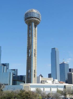  "Scenic view of the Dallas cityscape with notable buildings and landmarks under a bright sky, providing a sweeping perspective of the skyline."