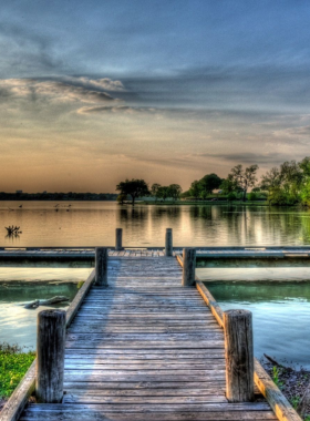 Peaceful scene at White Rock Lake Park in Dallas, Texas, with a serene view of the lake, surrounding trees, and people enjoying the natural landscape."