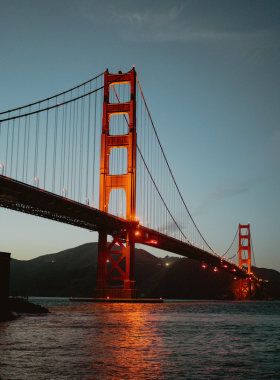 A captivating view of Fort Point with the Golden Gate Bridge towering above it. The historic brick fortification is framed by the bridge's impressive architecture, showcasing a blend of history and modern engineering.