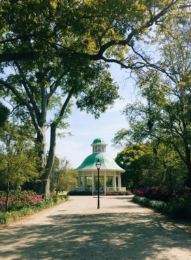 A beautifully designed bandstand located in Hampton Park, surrounded by vibrant flowers and lush greenery. The structure serves as a focal point for community events and outdoor concerts, embodying the lively spirit of Charleston's outdoor culture.